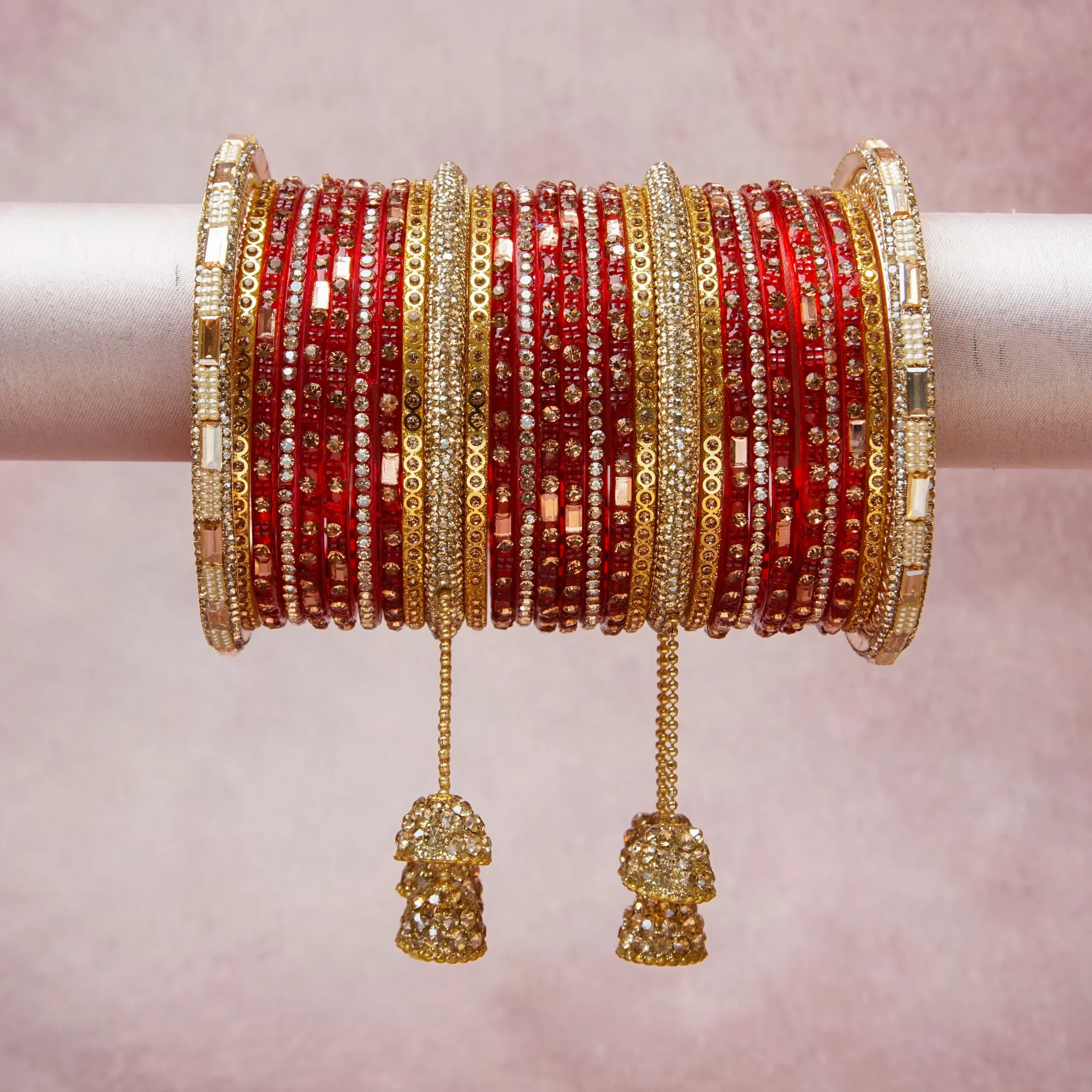 A grounding Crimson Red forms the heart of the set, while touches of Clear Crystal, Champagne Crystal, Cream Pearl add charm.

A thoughtful composition of Glass (for red bangles), Gold-plated Brass (for gold bangles, chains, and bells), Cubic Zirconia (for clear and champagne crystals), Imitation Pearl (for cream beads), designed to feel complete without being heavy.
Each element layers seamlessly, creating a look that is refined, wearable and quietly striking.